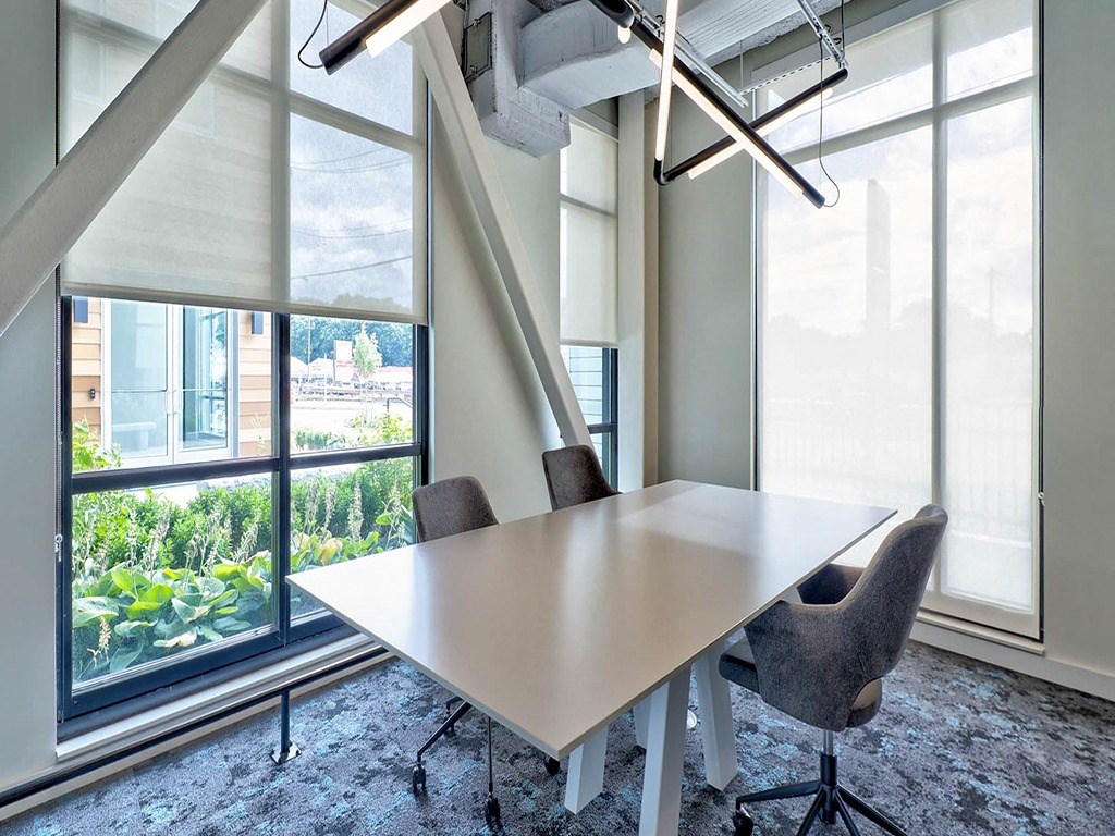a conference room with a large window and a table with chairs